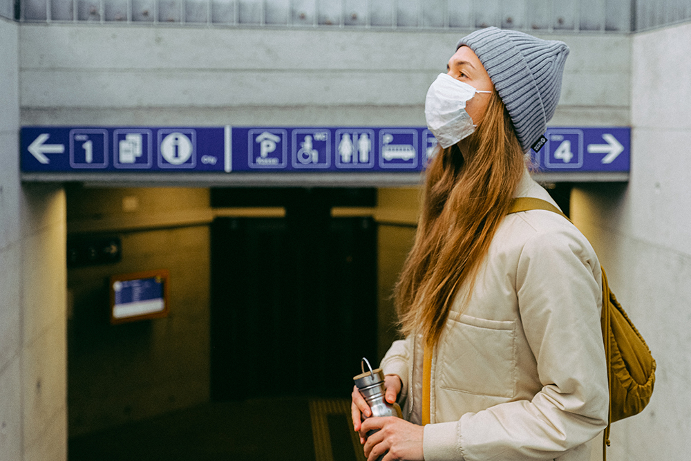 Woman wearing face mask waiting for public transportation